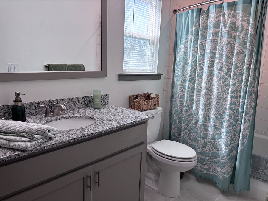 Your private bathroom!! View of bath/shower, toilet (with basket and complimentary popurri), and part of mirror and counter space.