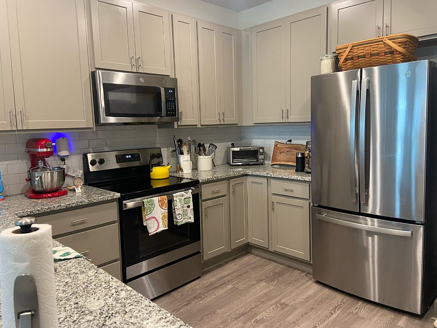 Look at right side of kitchen, including one of the available cutting boards, bread basket, refrigerator (less than 2 years old), and glimpse at coffee and espresso machines.