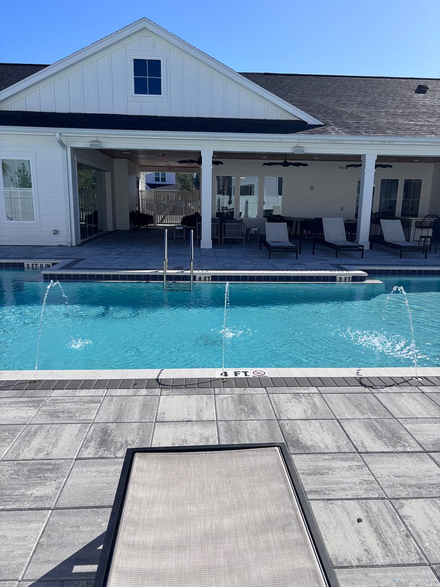 Look at the community pool and outdoor gathering space with TVS and outdoor kitchen.