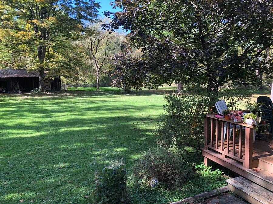 Two private acres with woods, trails and stream behind.