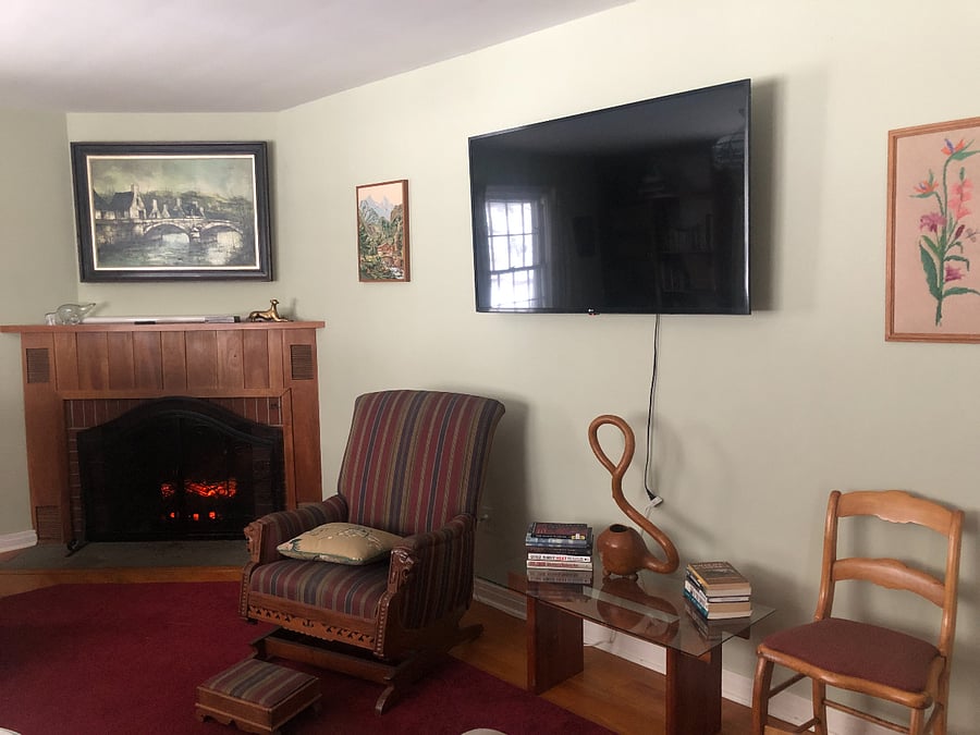 Living room with wall mounted smart TV and electric fireplace for ambiance.
