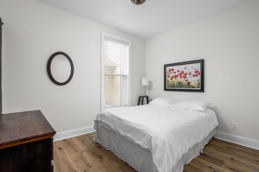 Cozy bedroom with a minimalist design, featuring a comfortable bed and warm decor.