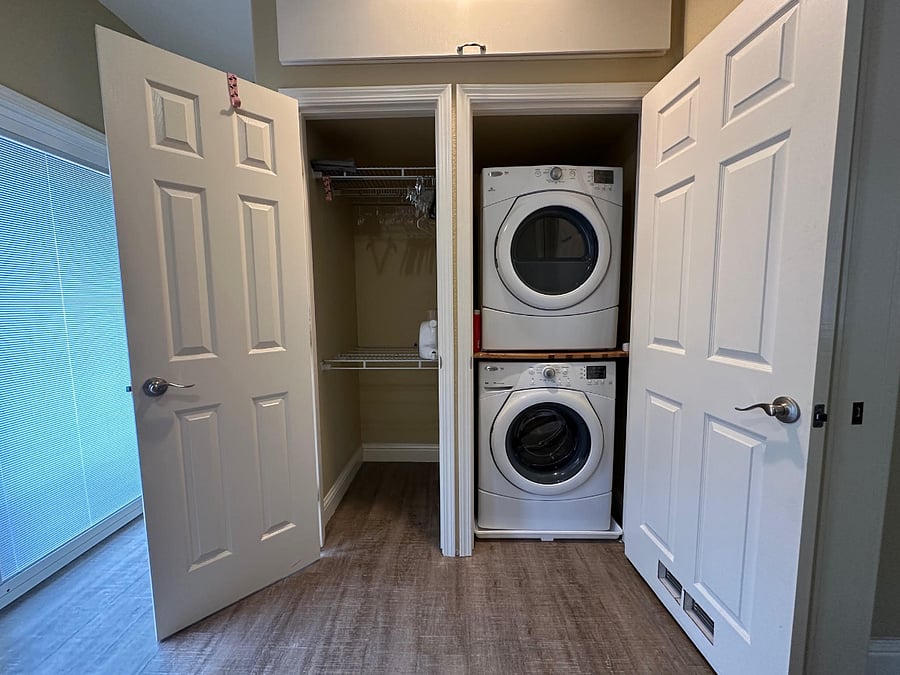 closet and full size washer and dryer in  bedroom