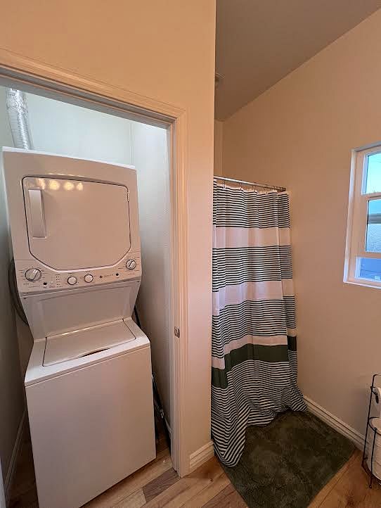 The stackable washer and dryer is located in the bathroom and has a door to close it off when not in use.