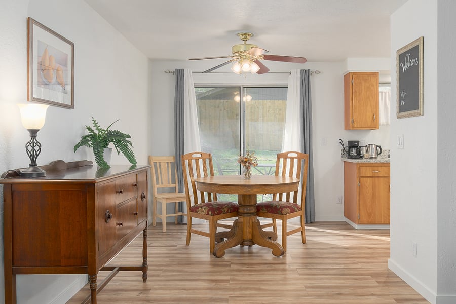 The treed back yard is visible out the back slider door and kitchen window.  Blackout curtains on the slider along with semi-sheers for light and privacy at the same time.