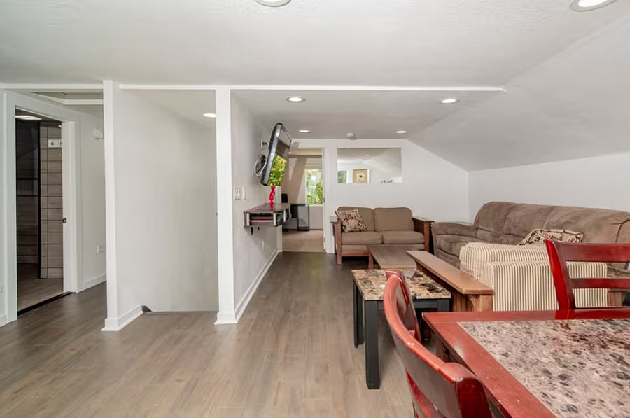 Open concept living room and dining room area, with stairs leading down to the front entryway.