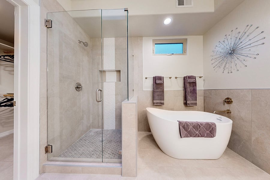 Soak away the day in this elegant bathroom featuring a spacious glass-enclosed shower, a luxurious soaking tub, two sink vanity, and modern decor perfect for unwinding after a day of work or family adventures.