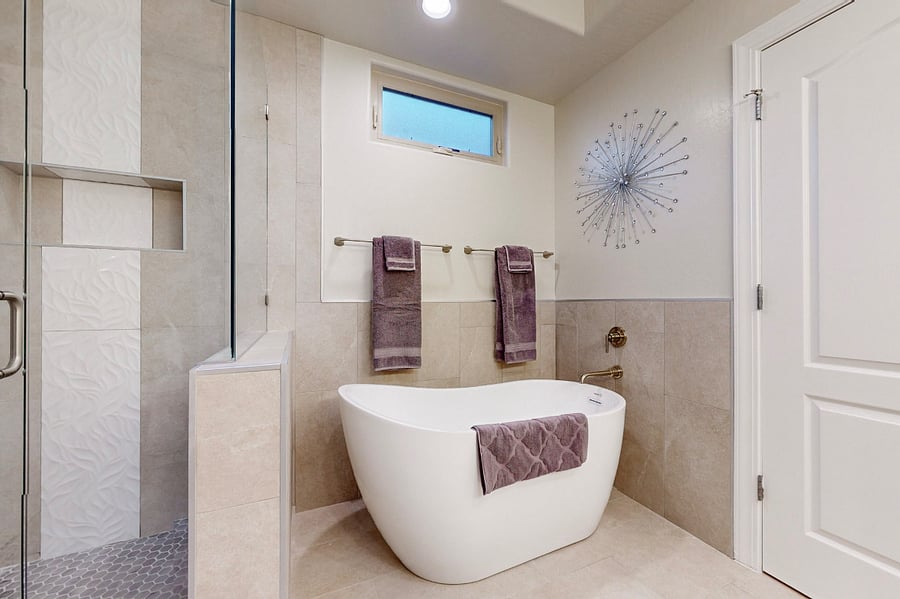 Soak away the day in this elegant bathroom featuring a spacious glass-enclosed shower, a luxurious soaking tub, two sink vanity, and modern decor perfect for unwinding after a day of work or family adventures.