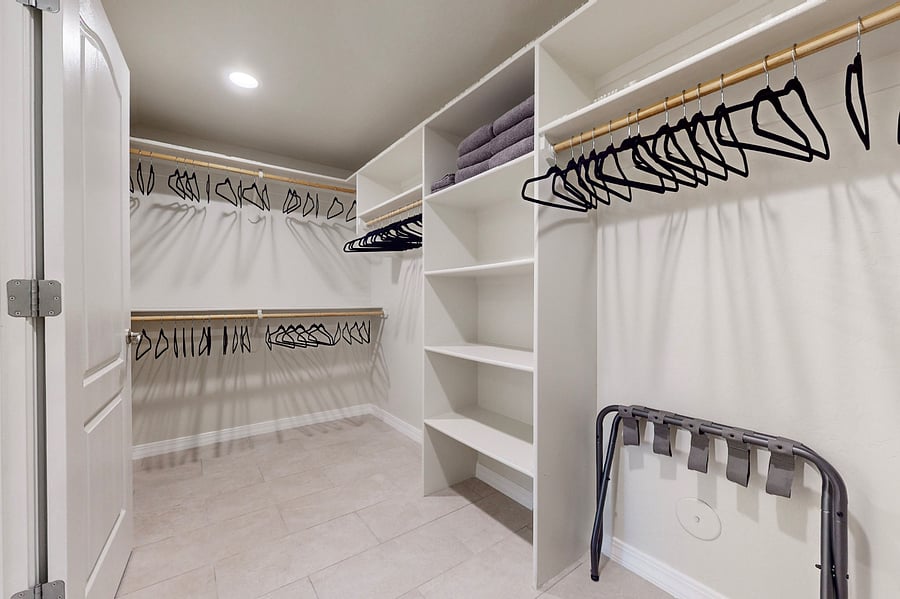 Organize effortlessly in a large walk-in closet featuring ample hanging space, shelves, and storage options, ideal for extended stays and keeping your family's belongings neatly arranged.