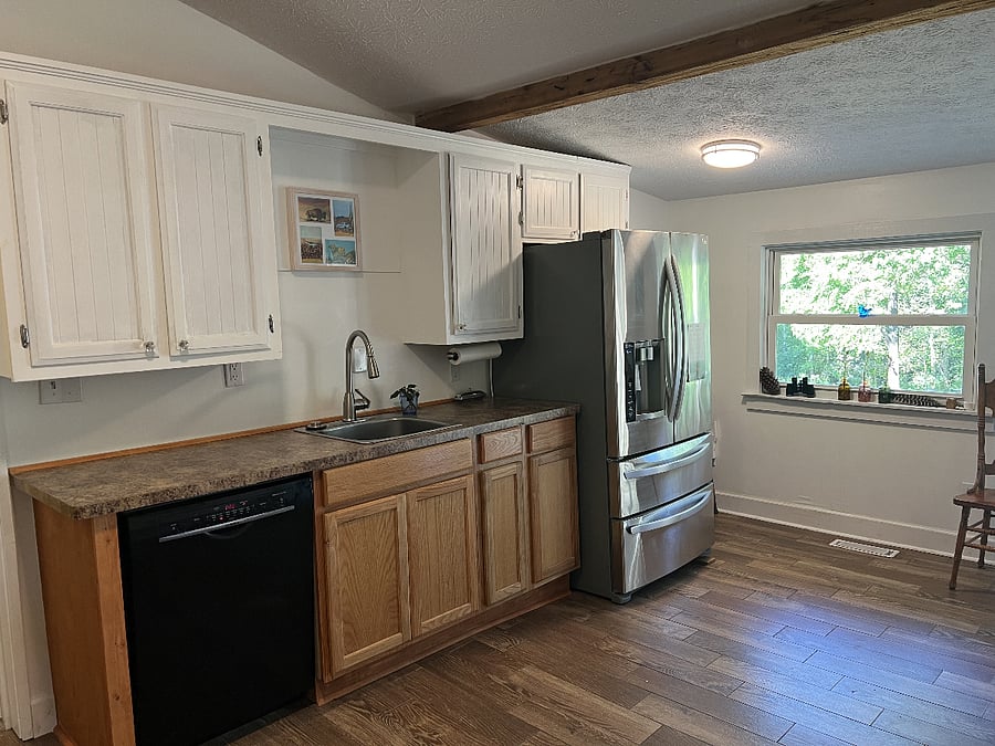 The shared kitchen has full-size appliances, a small dining table, and overlooks the back gardens.
