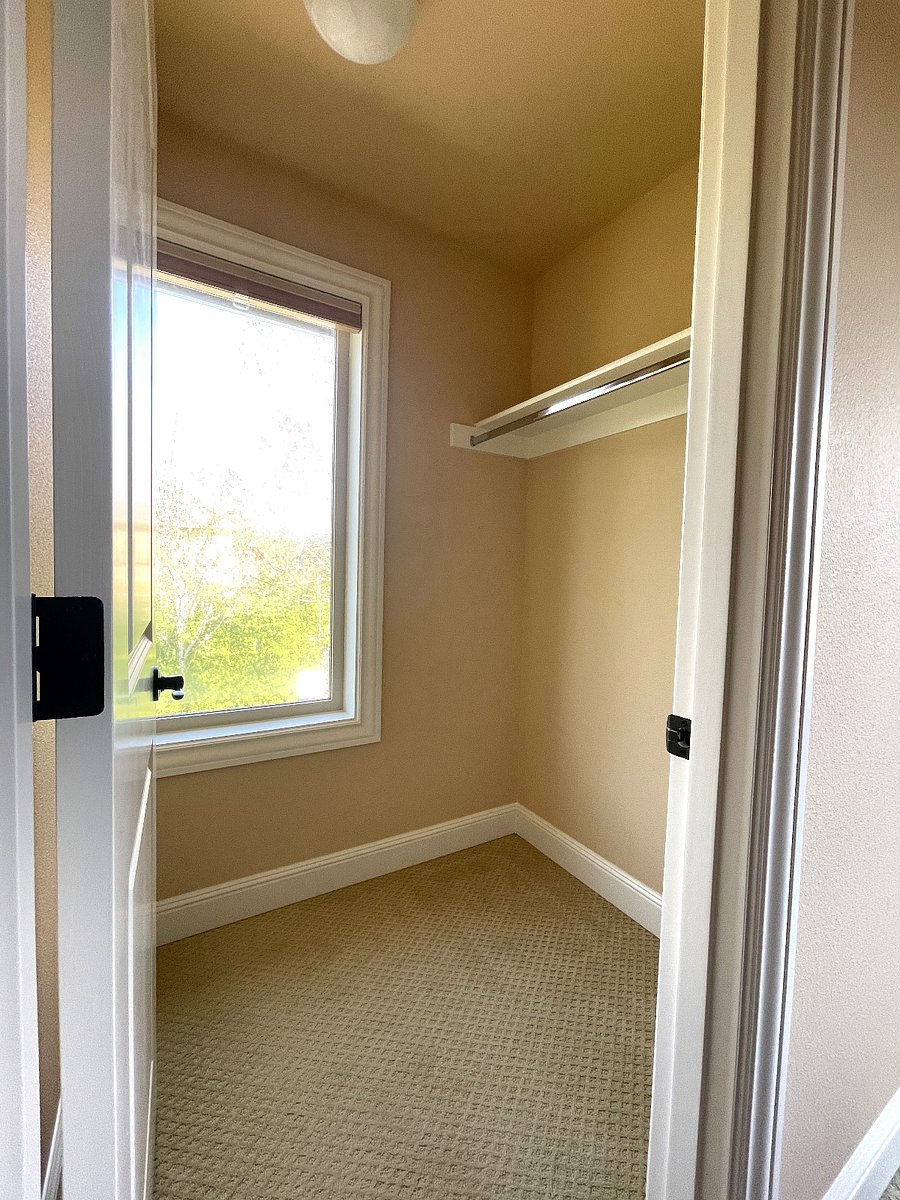 walk in closet.  Window has curtain.