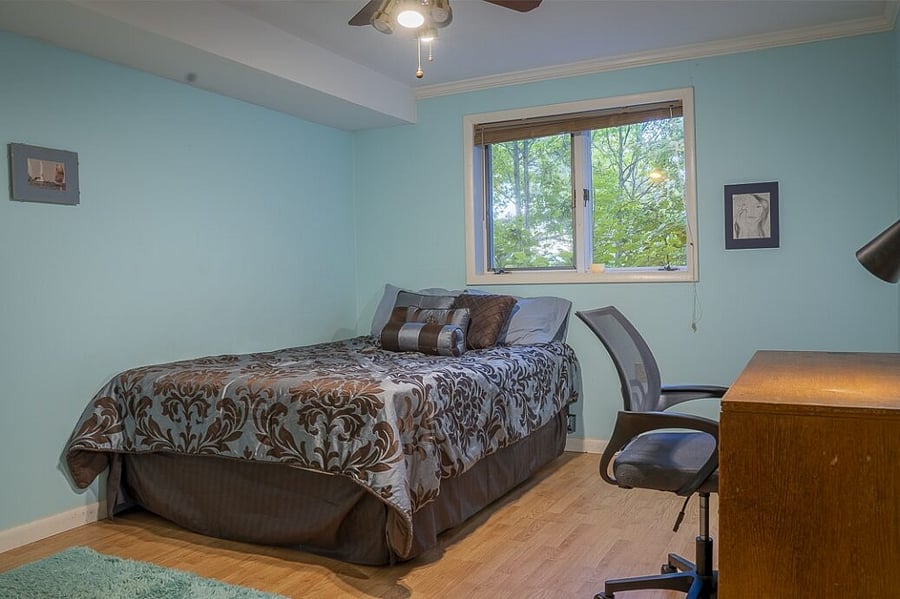 Lower level third bedroom with queen bed and dedicated workspace.