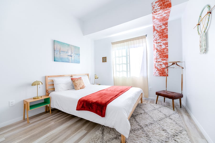 Relax in this bright and tranquil bedroom featuring a plush queen bed, vintage gentlemans valet chair, and striking Japanese-inspired textile art