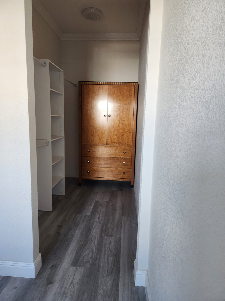 View of the walk-in closet with built-ins plus armoir