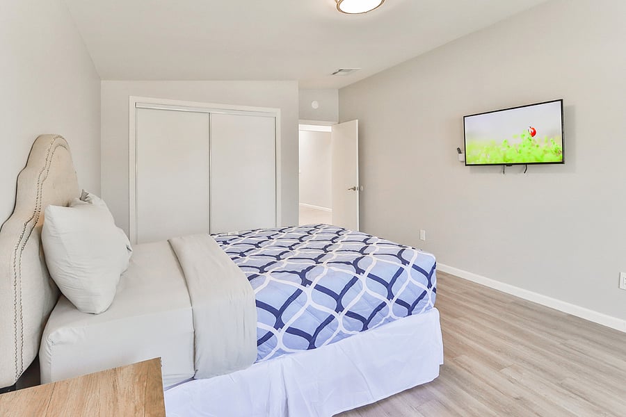 a comfortable and modern bedroom with a mounted TV