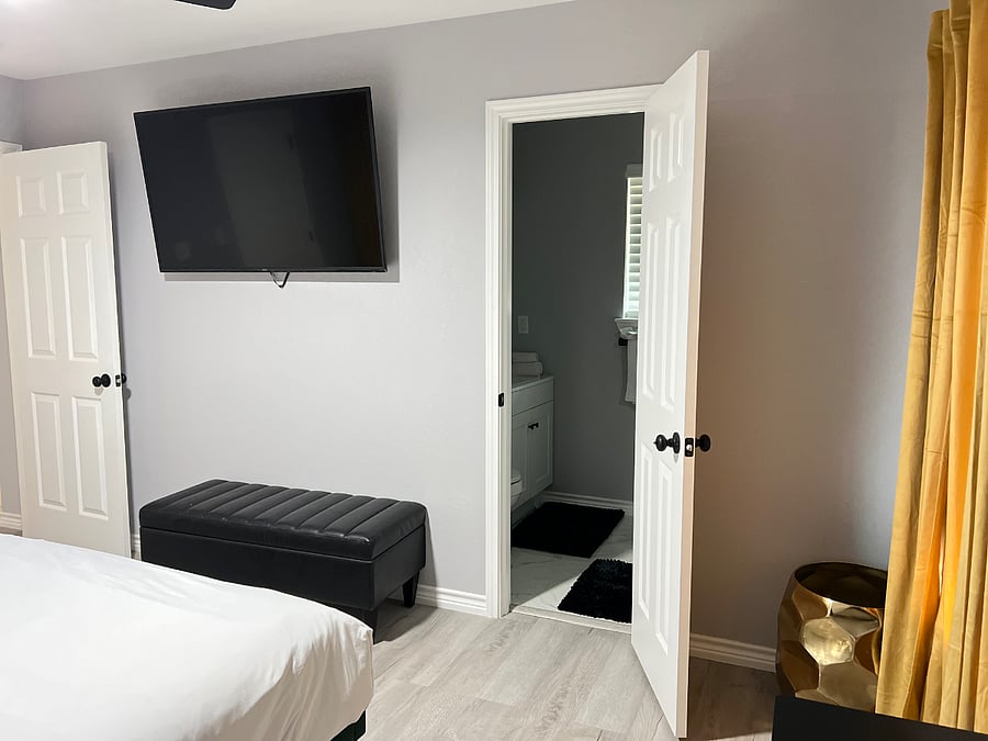 Spacious queen bedroom with direct access to a private en-suite bathroom featuring a luxury walk-in showerdesigned for comfort, privacy, and relaxation.