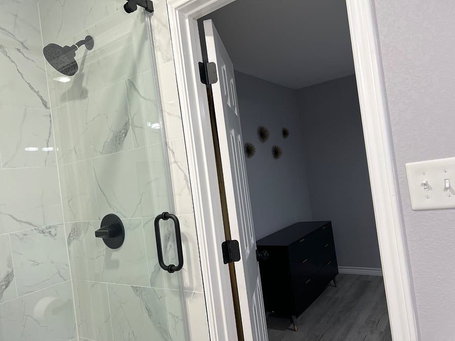 Spacious queen bedroom with direct access to a private en-suite bathroom featuring a luxury walk-in showerdesigned for comfort, privacy, and relaxation.