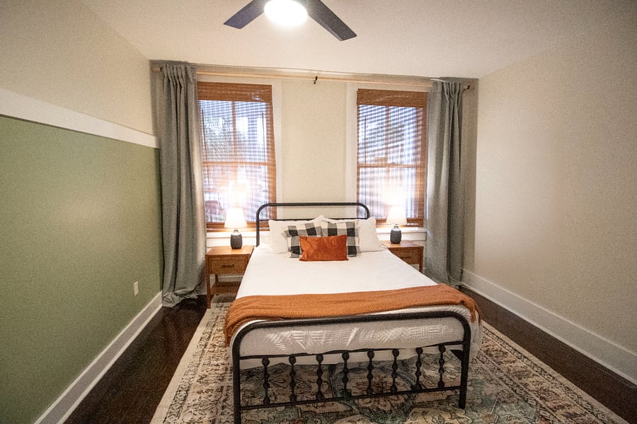 Queen-sized bed with luxury mattress, nightstands and black out curtains. Not shown is mini split AC unit. 