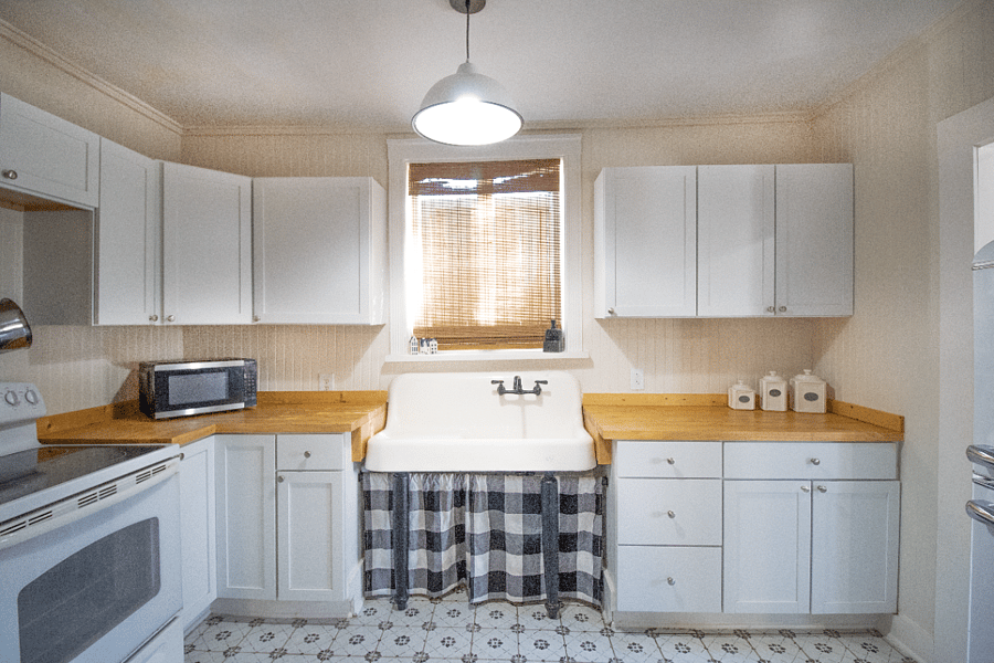 Remodeled kitchen featuring an original farmhouse sink and a vintagestyle refrigerator that add timeless charm to the space.