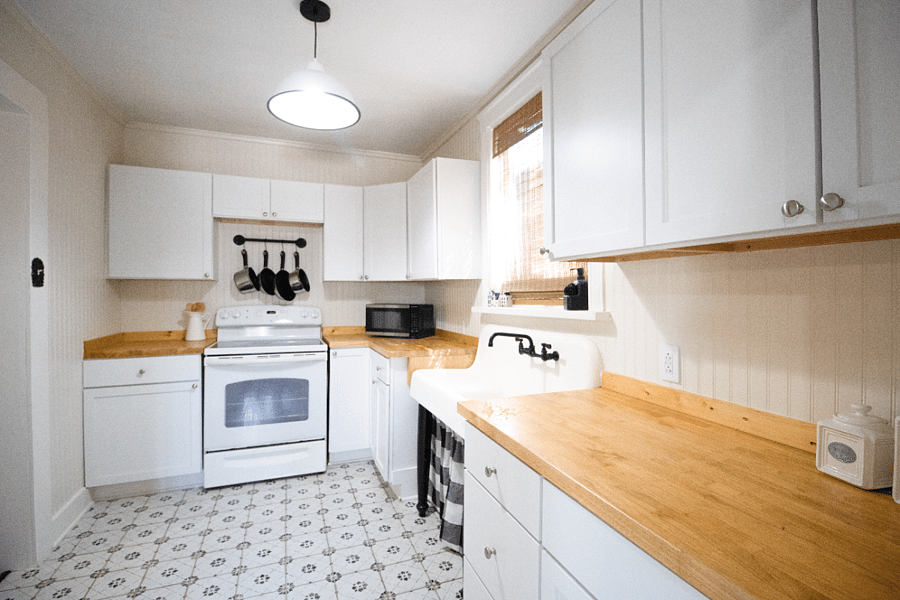 Kitchen includes stove, microwave, dishes pots and pans. 