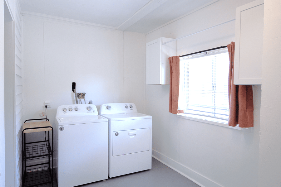 Roomy laundry space with full sized washer and dryer and built-in cabinets with plenty of storage.