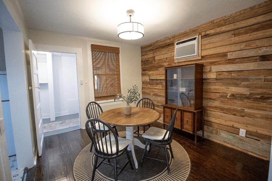Cozy dining nook with a warm wood accent wall, round table for four, and natural textures that create an inviting, relaxed atmosphere. Opens conveniently to the kitchen, laundry space and the study nook.