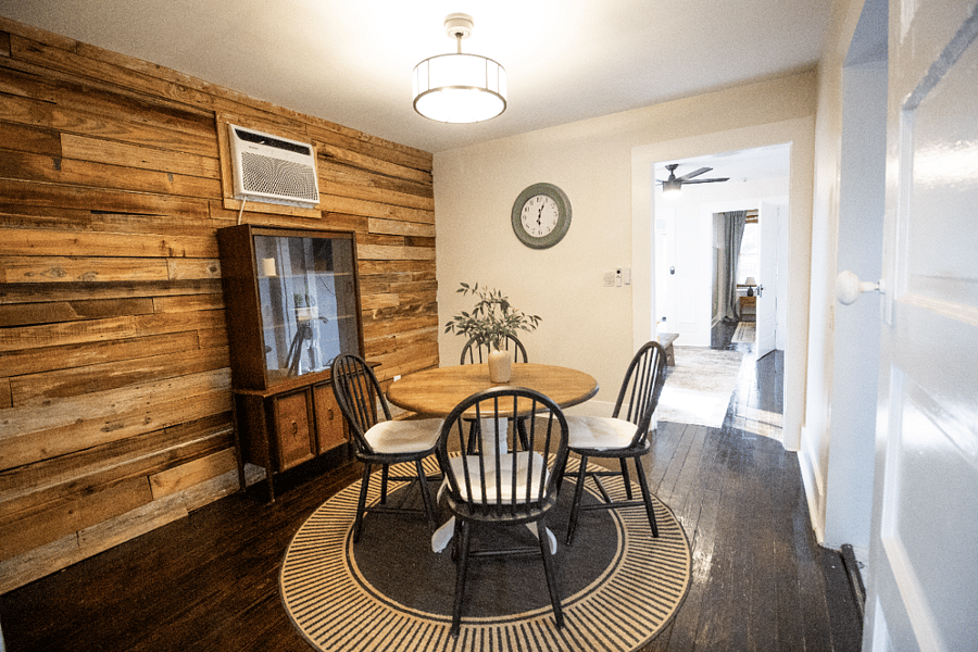 Charming dining area features a stylish overhead fan, a classic storage cabinet perfect for display/ extra organization and an easy flow into the living spaces.