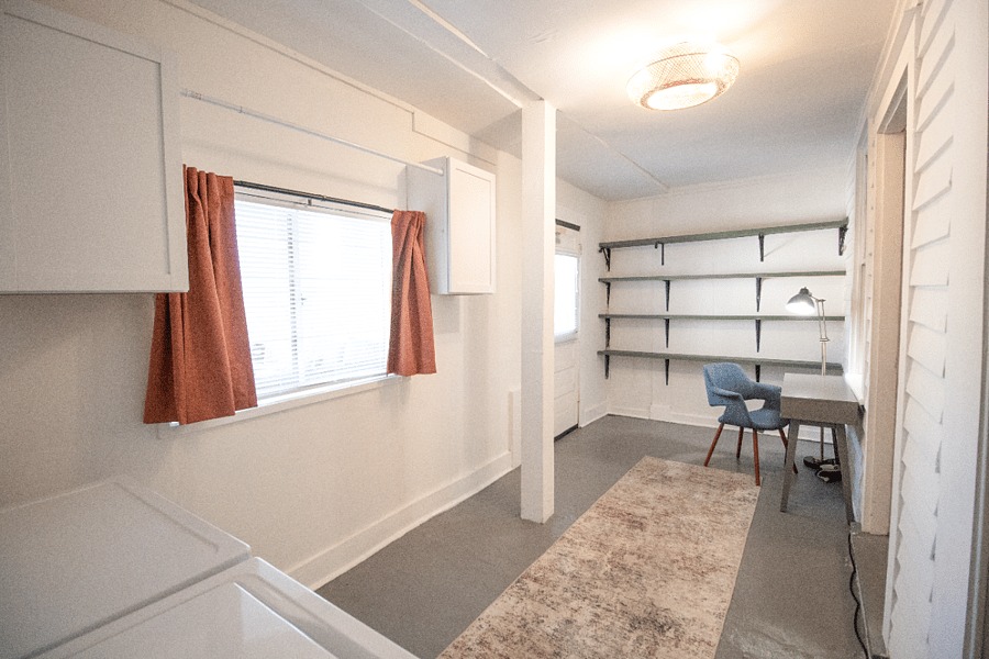 Spacious back room leading off the kitchen and dining room with plenty of storage, easily accommodating larger items like a bike. A boho-inspired fan adds the perfect touch of personality.