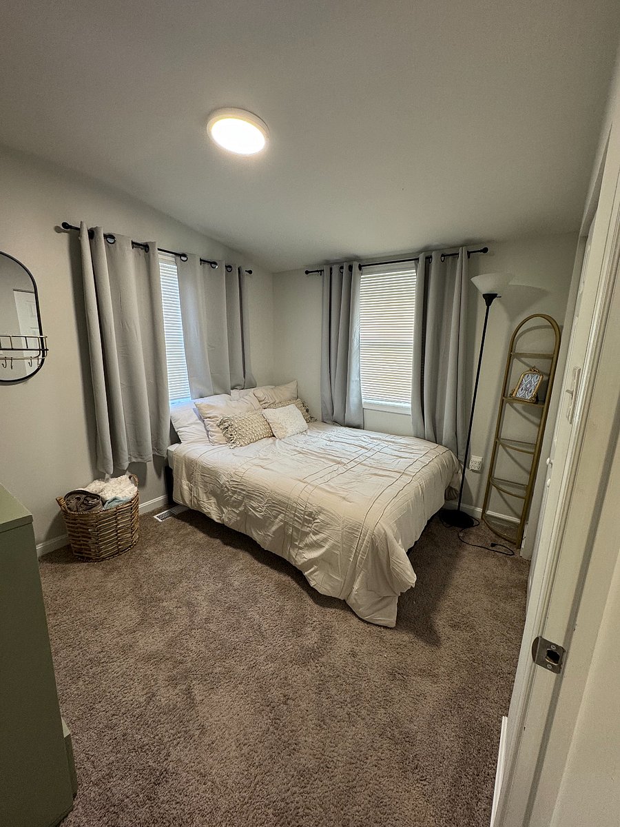 Bedroom with full mattress and blackout curtains