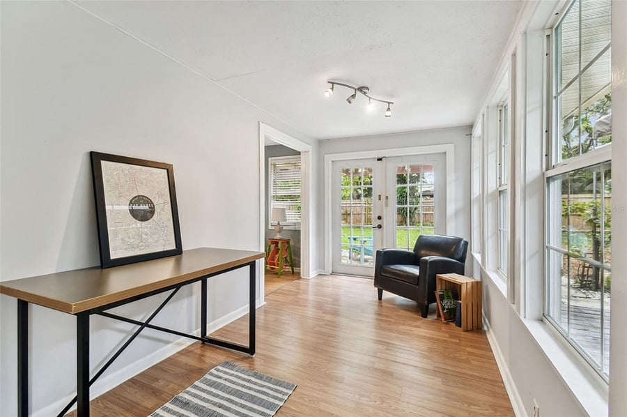 Light-filled sunroom serves as a versatile indoor-outdoor living space with direct yard access. Windows off natural light while offering serene views of the backyard. Perfect for morning coffee, casual dining, or a peaceful reading nook.