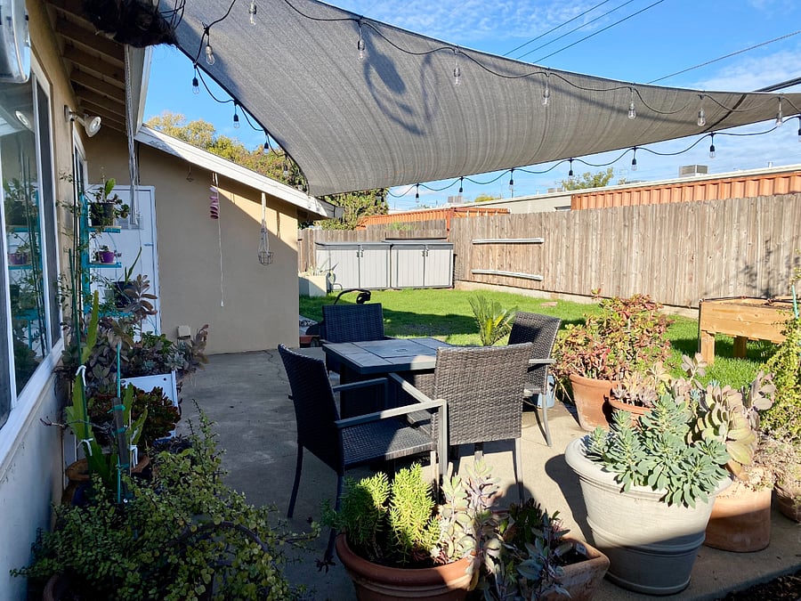 Back patio: seating with firepit table and twinkle lights for night time hanging out