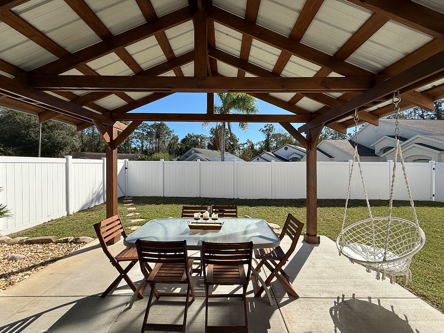 Outdoor dining table with six chairs and swing. Firepit area and plenty of room for pups to run around.