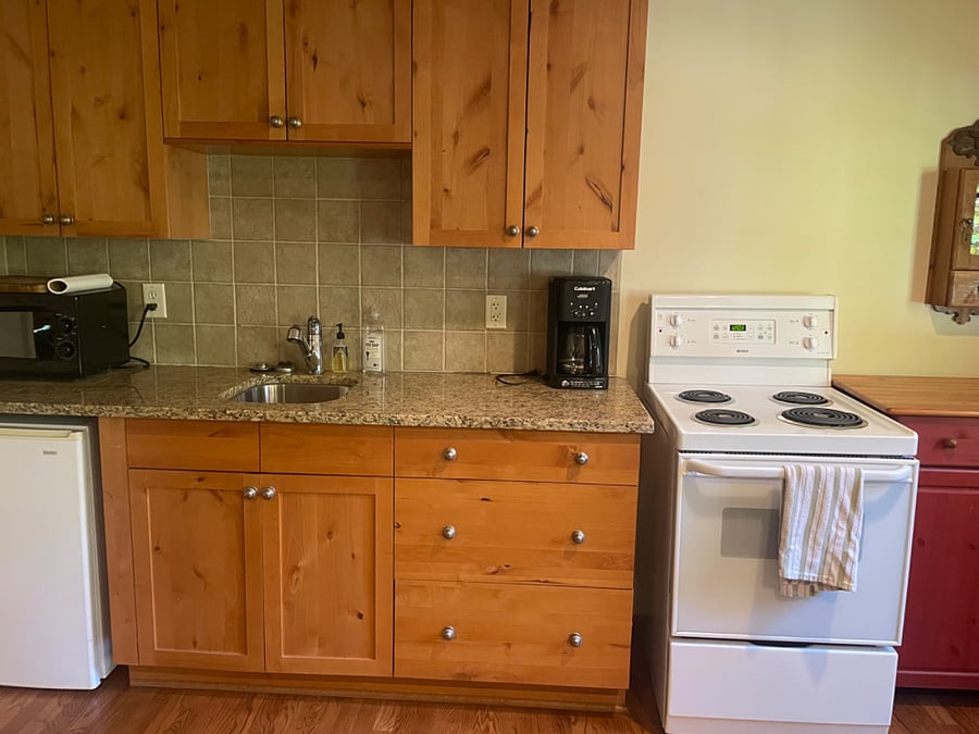 Kitchenette with stove, oven, and microwave. Can exchange mini-fridge for full refrigerator upon request.