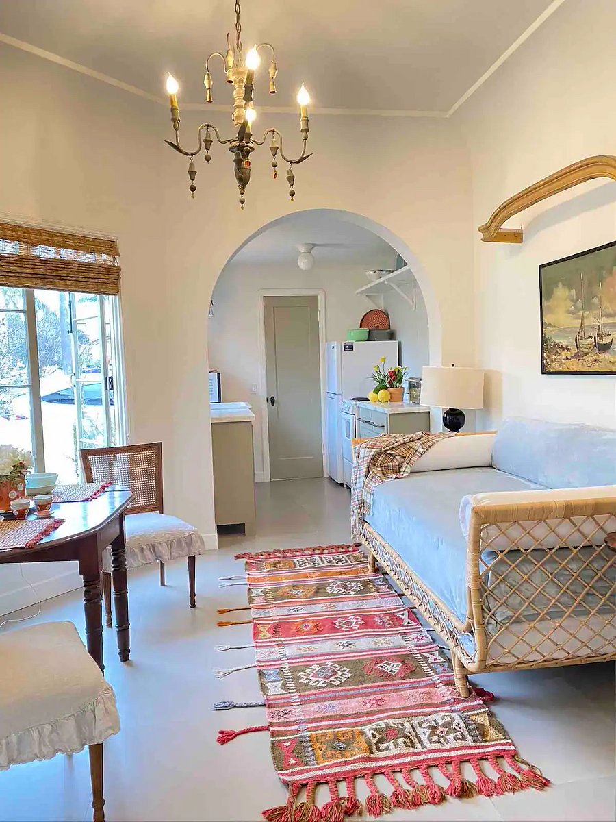 Bright and airy Dining area and daybed seating with a view of the kitchen beyond the archway.