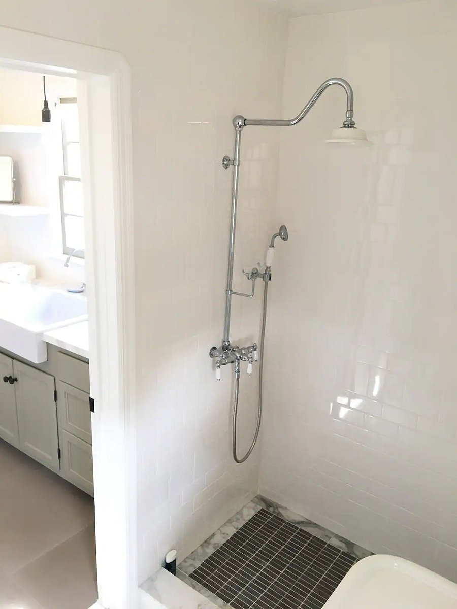 Walk-in shower with large overhead rain shower and a hand held combination.