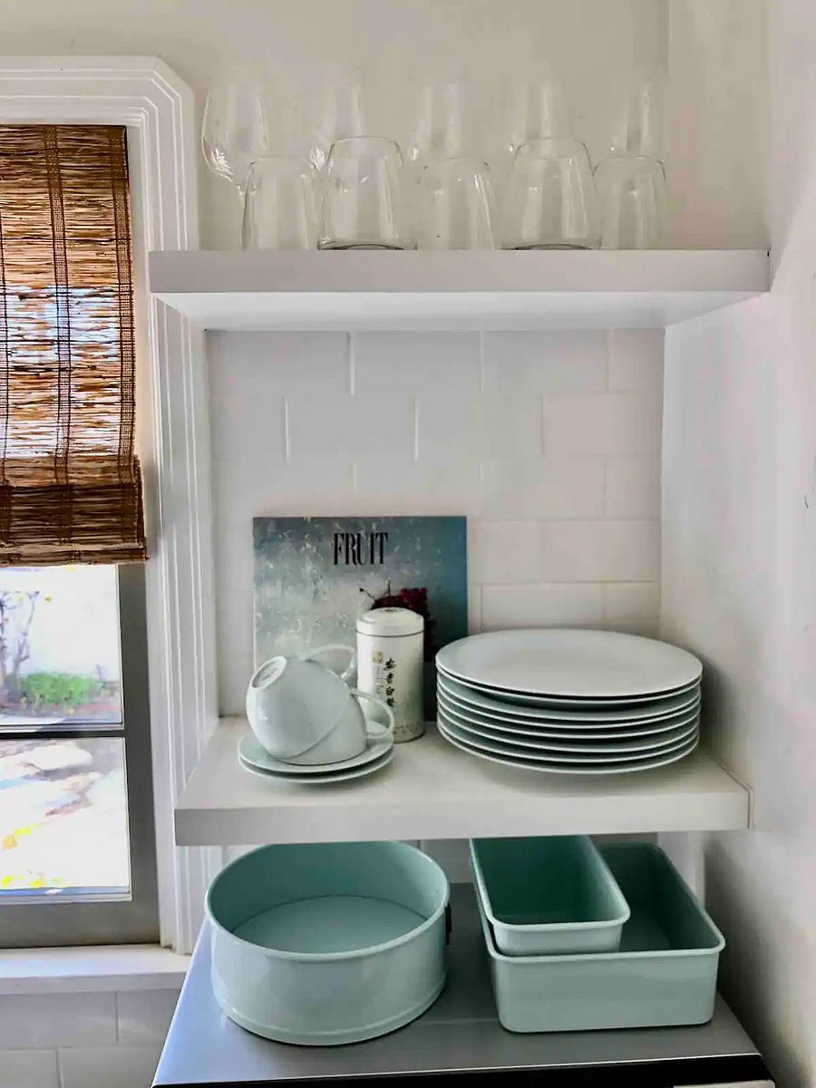 Serving dishes on open shelves in the kitchen.