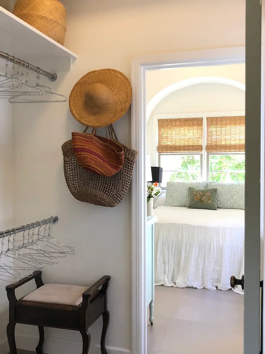 Spacious walk-in closet with hangers, shelving and built-in cabinetry.