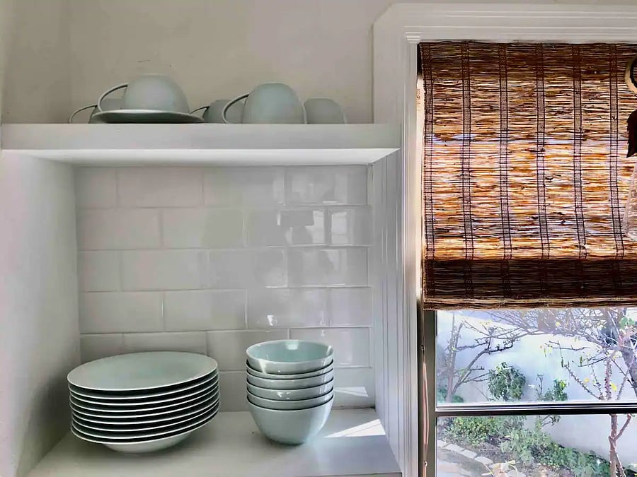Serving dishes on open shelves in the kitchen.