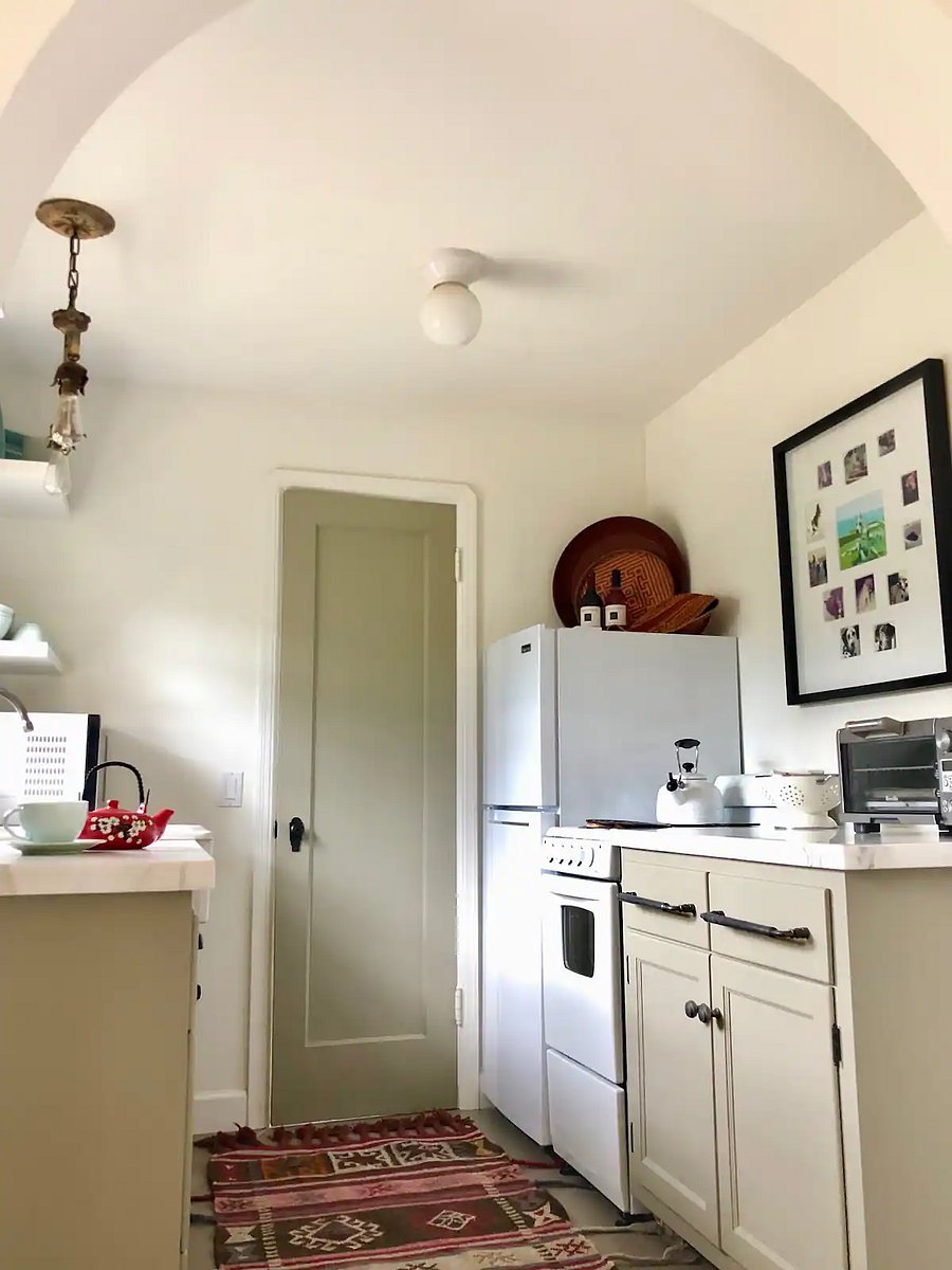 Kitchen wall with refrigerator, stove and countertop cabinet.