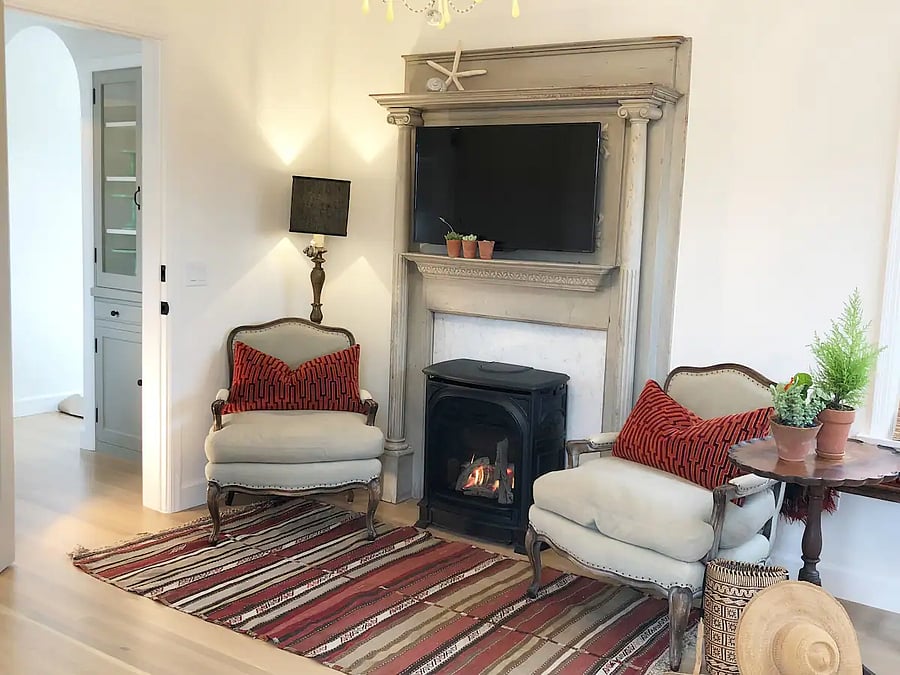 Upper mother in law guest quarters - Master Suite seating flaking antique mantel (with TV) surrounding a wall heater.
