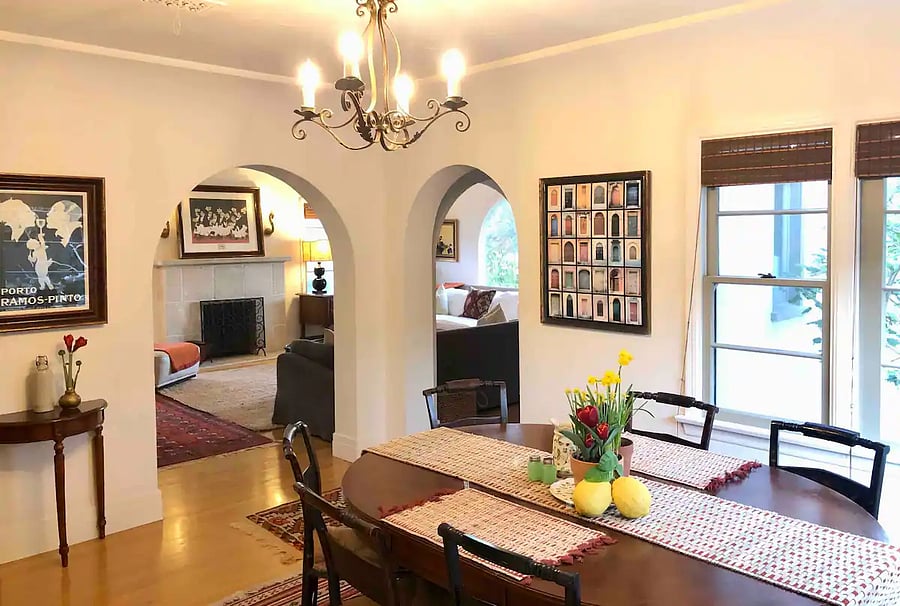 Main house - formal dining with a view of architectural arches leading to the Living room.