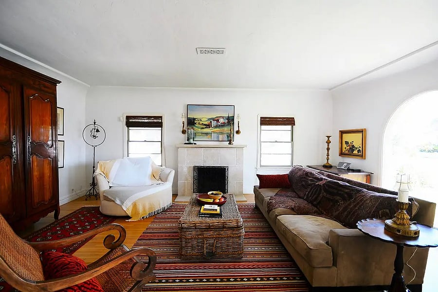 Another view of spacious living room with arched picture window and wood burning fireplace, in the main house.