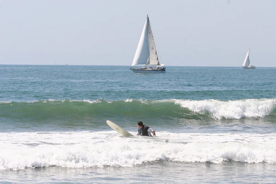 Watch sailing and surfing on the beach.