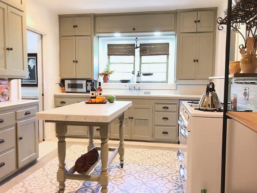 Another view of renovated kitchen with movable island in the middle over mission tile floor, in the main house