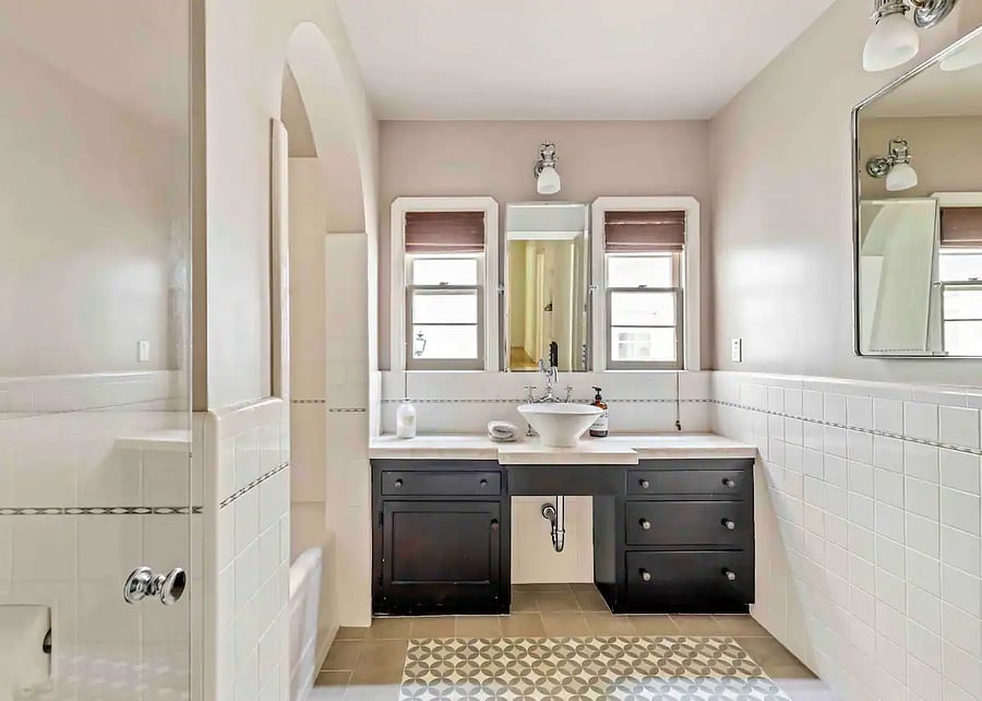 Well lit and spacious Master Bathroom with Calacatta stone counter and mission tile floor, in main house.