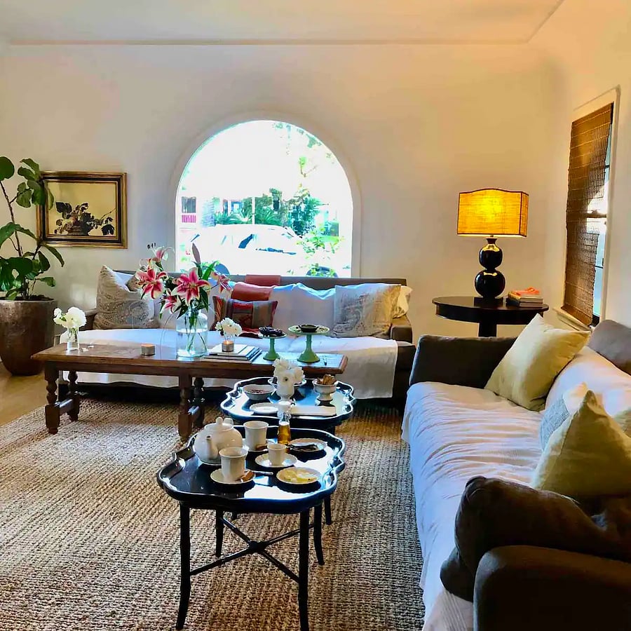 Main house - Living room with arched picture window behind linen sofas.