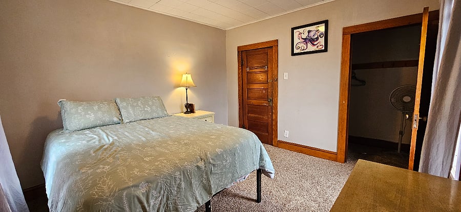 Green bedroom with queen bed