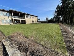 Backyard view - private apartment entrance under covered patio. Private parking to the right in large graveled area.