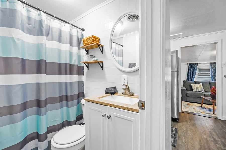 Bathroom with tub and vanity. Has a linen closet with plenty of storage right outside the bathroom door for extra storage.