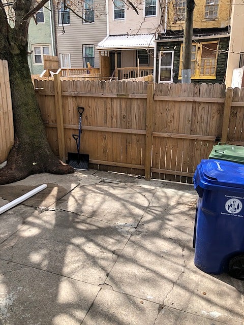 Patio at the back of the house with trash and recycling receptacles